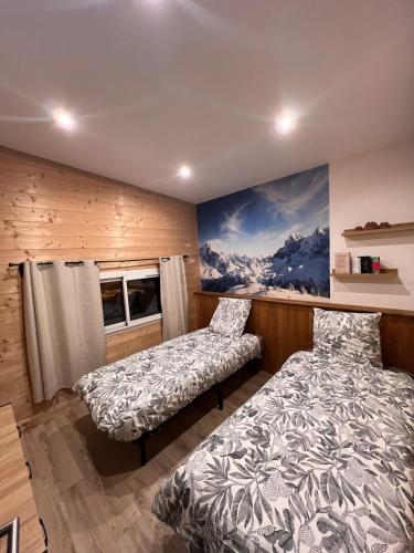 a bedroom with two beds and a painting on the wall at Loft-chalet 12 pers - Billiards - Cinéma - 10 min ski in La Cabanasse