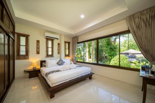 a bedroom with a bed and a large window at Chaweng Bay View Resort by Smith & Appy in Ko Samui