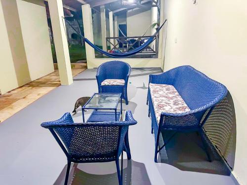 Zimmer mit 2 Stühlen, einem Tisch und einer Hängematte in der Unterkunft Casa da Vó Rita - praia do Cumbuco in Caucaia