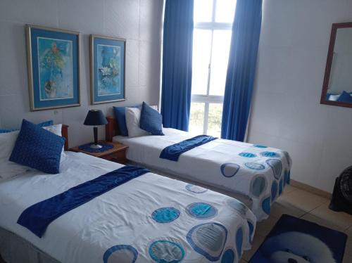 een hotelkamer met twee bedden en een raam bij Albatros 106 in Amanzimtoti