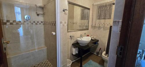 een badkamer met een wastafel en een douche bij Albatros 106 in Amanzimtoti