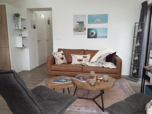 un soggiorno con un divano marrone e un tavolo di Velduil 62 a Hulshorst