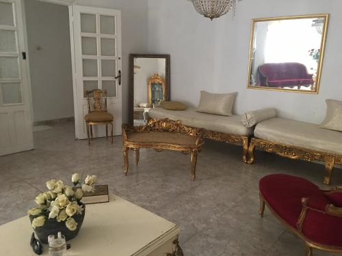 Una sala de estar con un sofá y un espejo. en Maison de Sila, en Bir el Djir