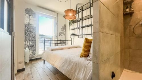 a bedroom with a bed and a window at Au Petit Vélo - Parking & Balcon Vienne in Vienne