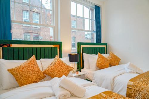 a room with two beds and two windows at NEW Luxurious Stunning Block Apartments in Central London in London