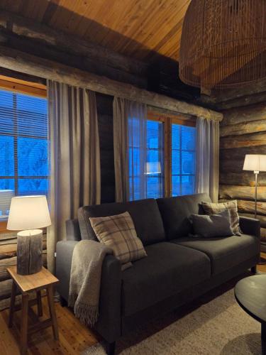 un soggiorno con divano e alcune finestre di Kelo Naava a Ruka