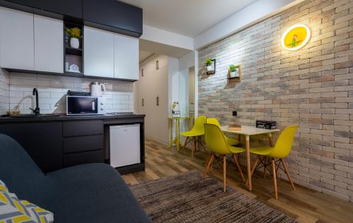 古多里New Gudauri - Feel Like a Kid - Cozy Apartment的厨房以及带桌子和黄色椅子的用餐室。