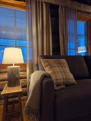 un soggiorno con divano, lampada e finestra di Kelo Naava a Ruka