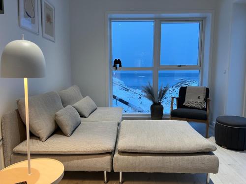 uma sala de estar com um sofá e uma janela grande em Private apartment with panoramic ocean views em Ilulissat