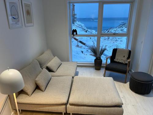 uma sala de estar com um sofá e uma janela grande em Private apartment with panoramic ocean views em Ilulissat