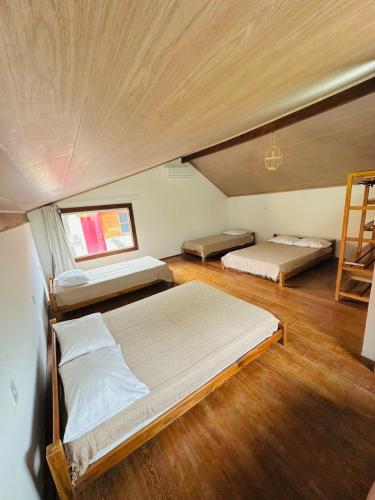 Cette chambre comprend 2 lits et une échelle. dans l'établissement Corumbau Chalé Casa, à Prado