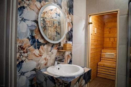 a bathroom with a sink and a mirror at Nebbia Ressort in Karpacz