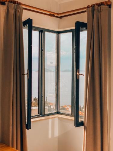 a room with three windows with a view of the ocean at The Bay View Hotel Kalkan in Kaş