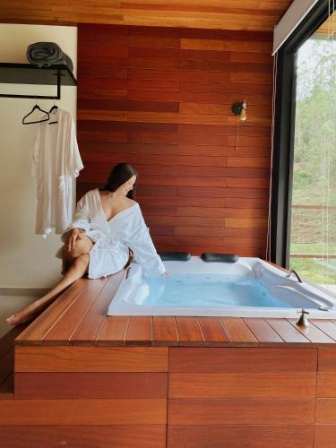 a woman sitting in a bath tub in a room at Cabana Terra Nossa com vista in Marechal Floriano