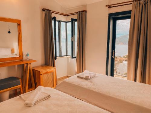 Una habitación de hotel con dos camas y una ventana. en The Bay View Kalkan Hotel, en Kas