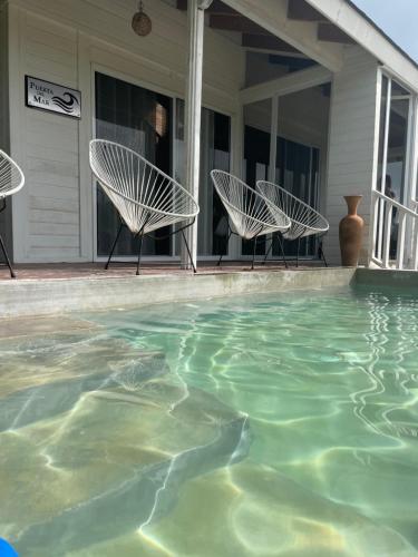 two chairs and a swimming pool on a house at HOLBOX PUERTA DEL MAR in Holbox Island