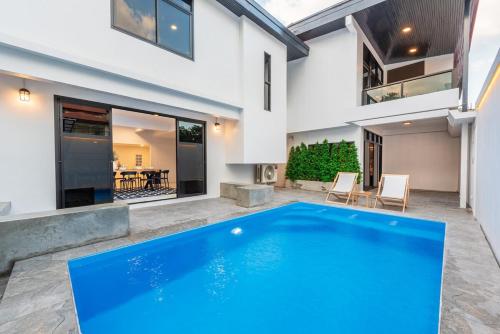 ein Swimmingpool im Hinterhof eines Hauses in der Unterkunft SavasdeeVilla Midtown bangkok in Makkasan