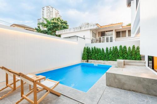 ein Swimmingpool im Hinterhof eines Hauses in der Unterkunft SavasdeeVilla Midtown bangkok in Makkasan