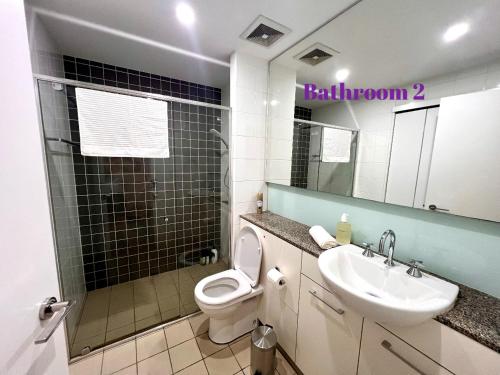 a bathroom with a toilet and a sink and a mirror at Wolli Creek Entire 2-Bedroom apartment with 2 bathrooms in Sydney