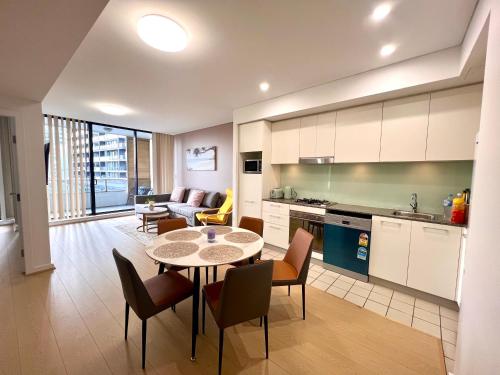 a kitchen and living room with a table and chairs at Wolli Creek Entire 2-Bedroom apartment with 2 bathrooms in Sydney