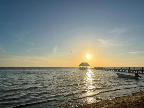 een strand met een pier en een boot in het water bij HOLBOX PUERTA DEL MAR in Holbox Island