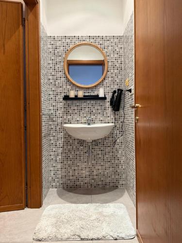 a bathroom with a sink and a mirror at La Dimora di Siena in Tognazza