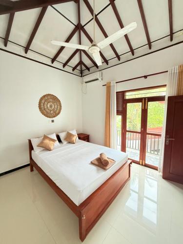 a bedroom with a bed and a large window at Pineapple Surf Villa in Ahangama
