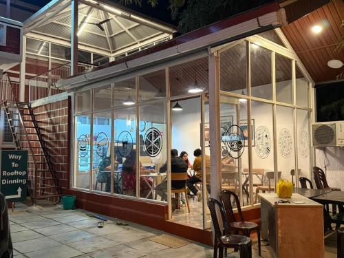 a restaurant with people sitting at tables in the window at Western Castle Stay n lawn in Coimbatore