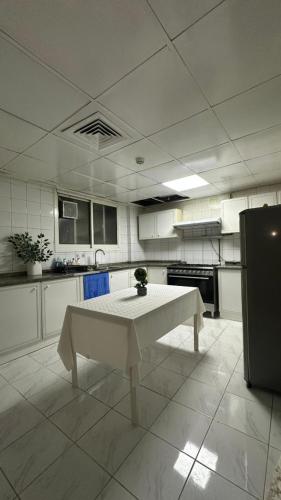 a white kitchen with a table in the middle of it at Single bed in al Majaz 2 - سوبر ديلوكس سرير مفرد في شقة فندقية in Sharjah