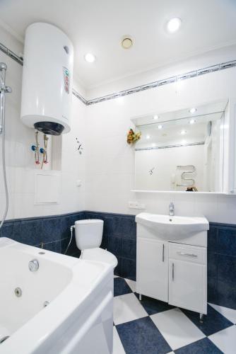 a bathroom with a white sink and a toilet and a tub at Partner Guest House Baseina in Kyiv