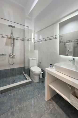 a bathroom with a toilet and a shower and a sink at NAMASTEmilos in Pachaina