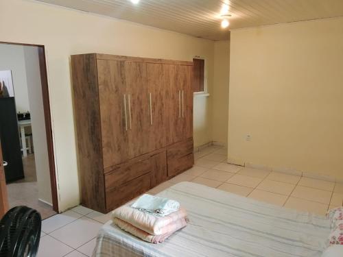 een kamer met een grote houten kast en een bed bij Kitnet com garagem e Wi-Fi in Tramandaí