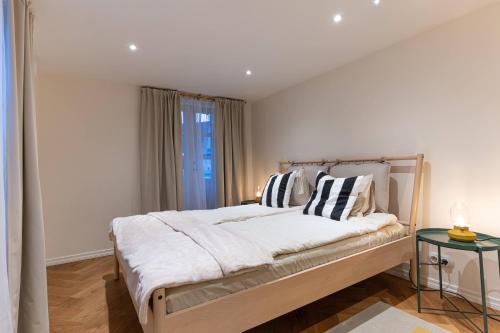 a bedroom with a bed with pillows and a window at Fellin Apartment in Viljandi