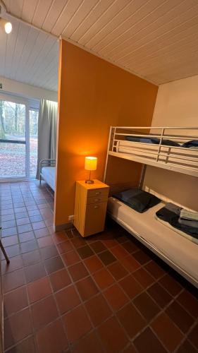 a room with two bunk beds and a lamp at Ceder 9 Hengelhoef in Aan de Wolfsberg