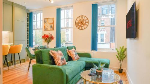 a living room with a green couch and a table at NEW Luxurious Stunning Block Apartments in Central London in London
