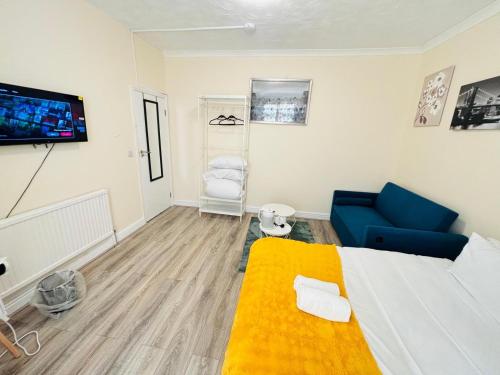 a room with a bed and a couch and a tv at London Budget-Friendly Stay in London