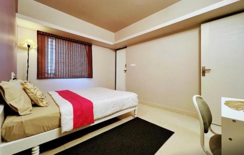 een slaapkamer met een bed, een bureau en een raam bij Eden Green Nest in Bangalore