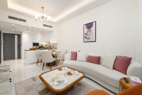 a living room with a white couch and a table at Private Pool Stylish 1BR Arjan in Dubai