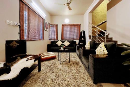 バンガロールにあるEden Green Nestのソファとテーブルのあるリビングルーム