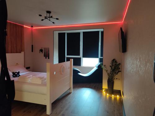 een slaapkamer met een wit bed en een rood licht bij Тематичні апартаменти in Zhytomyr