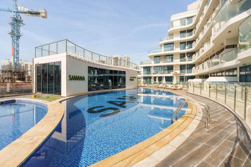 a large swimming pool next to a building at Private Pool Stylish 1BR Arjan in Dubai