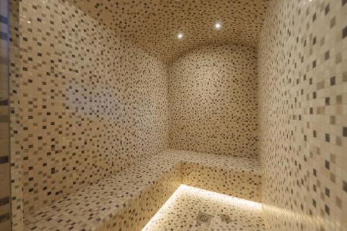 a bathroom with a shower with a tiled wall at Private Pool Stylish 1BR Arjan in Dubai