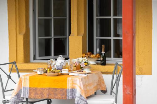 a table with a yellow table cloth on it with a table at Château de Marnand - Duplex à la ferme in Granges-près-Marnand