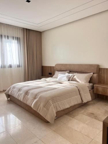 a bedroom with a large bed and a window at Hawana Apartment in Salalah