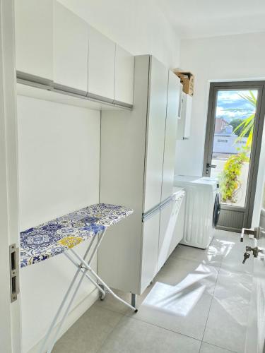 a kitchen with white cabinets and a bench in it at Tempus Central - Bazaar Metro Supermarket Resto in Quatre Bornes