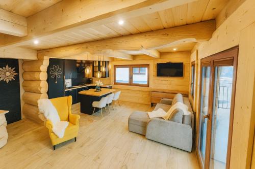 a living room with a couch and a dining room at Villa Alexandra jacuzzi i sauna in Kościelisko