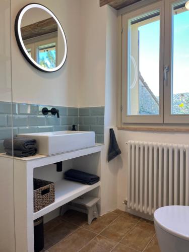 un bagno con un lavandino bianco e uno specchio di Mia Piccola Casina ad Arcevia