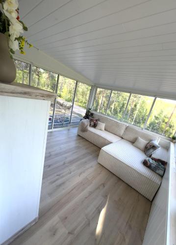 a living room with two white couches and wood floors at Vilt Hjerte Stugas in Sysslebäck