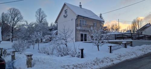 una casa coperta di neve di fronte a un edificio di Valdora - Forest Oasis 