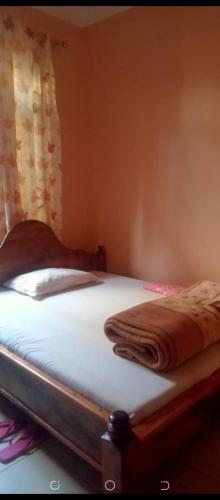 een bed in een slaapkamer met een deken erop bij Latricia Home Stay in Moshi